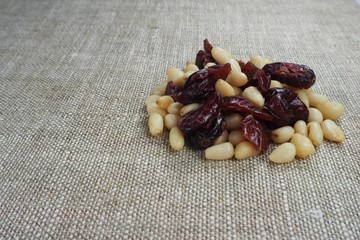 pine nuts with dried cranberries isolated on sackcloth background