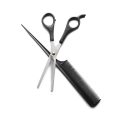 Professional hairdresser's scissors and hair comb on white background