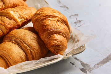 Tray with tasty croissants on table