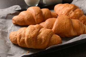 Tasty croissants on baking tray