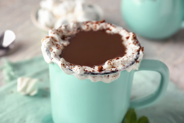 Cup of delicious cocoa on table, closeup
