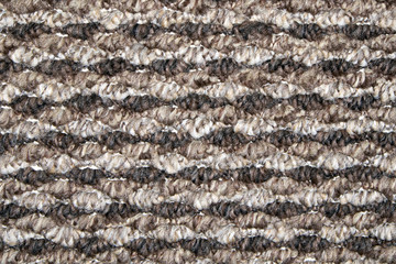 Brown and beige synthetic floor carpet covering with wavy geometric pattern, may be used as background or texture