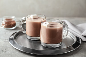 Cups of delicious cocoa with marshmallows on light table