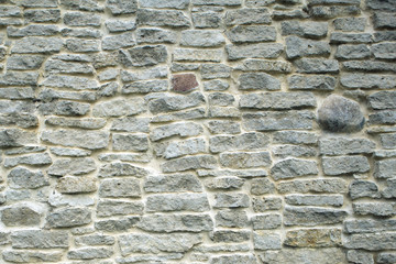 Masonry texture, fragment of ancient crumbling limestone brick fortress wall