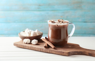 Cup of delicious cocoa with marshmallows on board