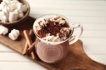 Cup of delicious cocoa with marshmallows on board