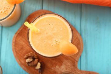 Glass with tasty melon smoothie on color table