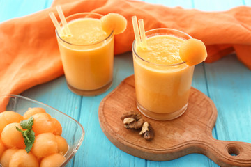 Glasses with tasty melon smoothie on  color table