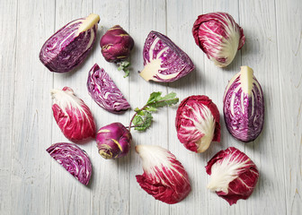 Different types of cabbage on light wooden background