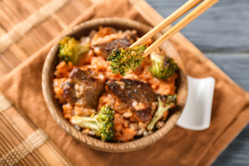 Eating of boiled rice with meat and broccoli, closeup