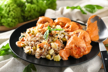 Plate with boiled rice, vegetables and meatballs on table