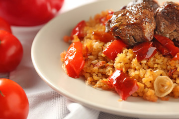 Plate with boiled rice, meat and sweet pepper on table, closeup