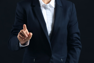 Businesswoman using virtual screen on dark background