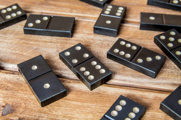 Black old, vintage dominoes on a wooden table closure. The concept of the game dominoes. Selective...