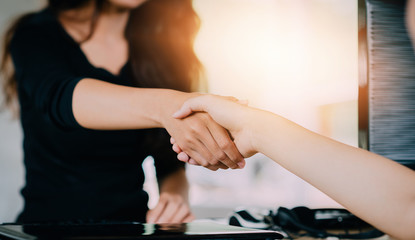 Business negotiation,Image of asian businesswomen Handshaking,happy with work,Handshake Gesturing People Connection Deal Concept.