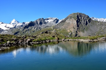 Naklejka na ściany i meble Berge der Ortlergruppe in den Alpen spiegeln sich im Bergsee neben der Martellerhütte in Südtirol
