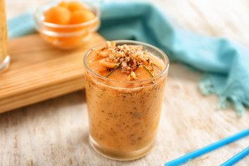 Glass of tasty melon smoothie on wooden table