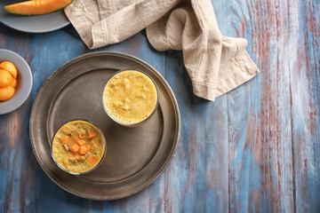 Composition with tasty melon smoothie on wooden table