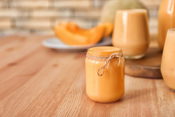 Jar of tasty melon smoothie on wooden table