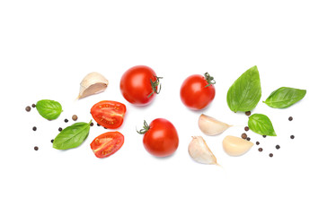 Delicious tomatoes with fresh basil and spices on white background