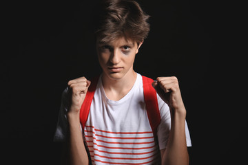 Bully teenage boy on dark background