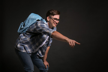 Laughing bully teenage boy on dark background