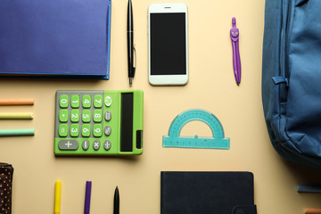 Composition with different school stationery and phone on light background