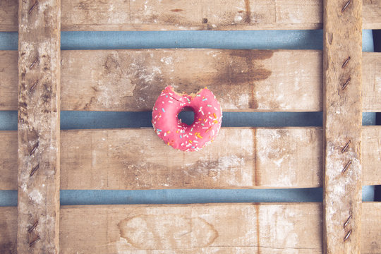 pink donut on wooden background