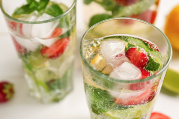 Glasses of fresh strawberry lemonade on light table, closeup