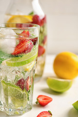 Glass of fresh strawberry lemonade on light table