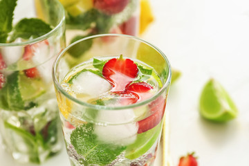 Glasses of fresh strawberry lemonade on light table, closeup