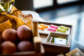 Freshly Baked Bread with Homemade Butter and Glass of White Wine standing on the Table in Luxury Restaurant