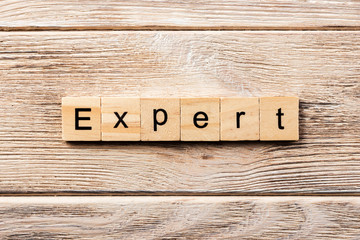 expert word written on wood block. expert text on table, concept