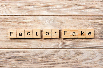 fact or fake word written on wood block. fact or fake text on table, concept