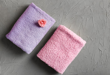 Soft towels with flower on grey background
