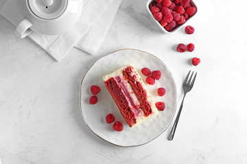 Plate with piece of delicious raspberry cake on light table