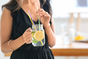 Young woman with mason jar of fresh lemonade, closeup