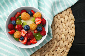 Delicious fruit salad in bowl on wicker mat