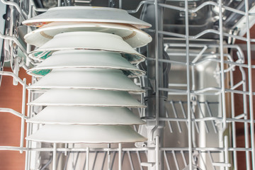 Stack of white plates loaded into the dishwasher