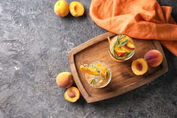 Wooden board with glasses of tasty cocktails on dark table
