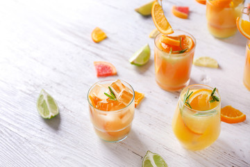 Glasses of tasty cold cocktails on white wooden table