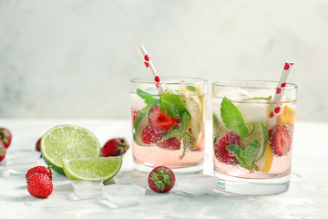 Glasses of fresh strawberry lemonade on light table
