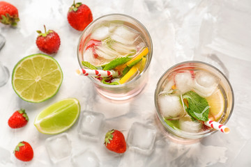 Glasses of fresh strawberry lemonade on light table