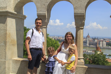 happy family traveling with two children smiling look at the camera on the streets of Budapest,...