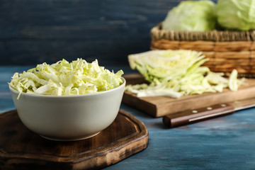 Bowl with shredded cabbage on wooden board