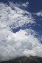 Mountains with white clouds on a blue sky background