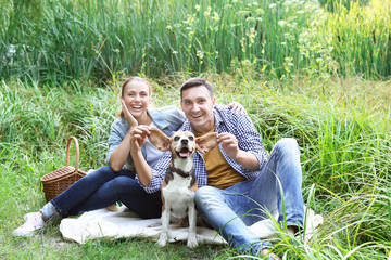 Young couple with cute dog resting in park © Pixel-Shot