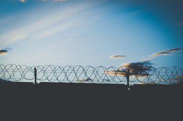 barbed wire on background of blue sky