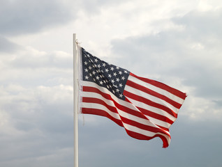 American flag on a blue sky with clouds background