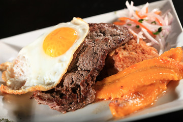 Peruvian traditional steak with fried egg an banana tacu tacu